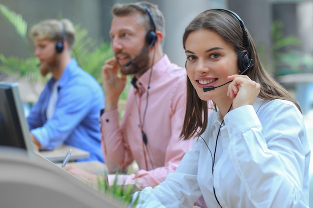 Attractive positive young businesspeople and colleagues in a call center office