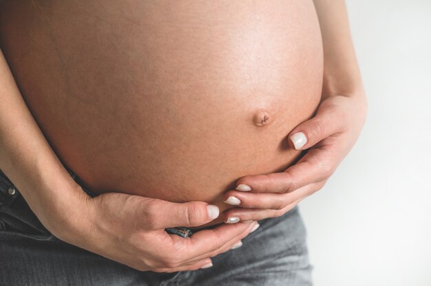 Attractive pregnant woman holding her belly