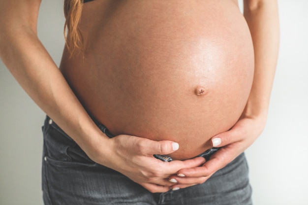 Attractive pregnant woman holding her belly