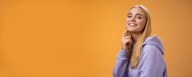 Attractive sassy selfassured caucasian blond female in purple hoodie turning camera touching chin ch