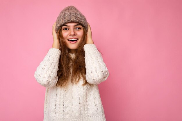 Attractive smiling happy young brunet woman standing isolated over colorful background wall wearing