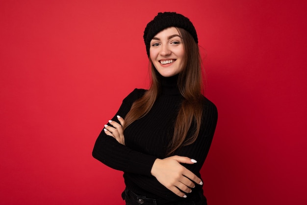 Attractive smiling happy young brunette woman standing isolated over colorful background wall