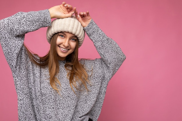 Photo attractive smiling happy young dark blonde female person standing isolated over colorful background wall wearing everyday stylish outfit showing facial emotions looking at camera