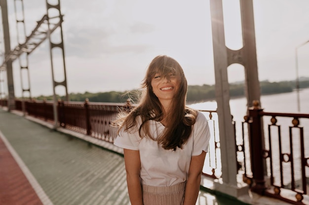 Attractive smiling woman with wonderful smile laughing with closed eyes wearing in white tshirt