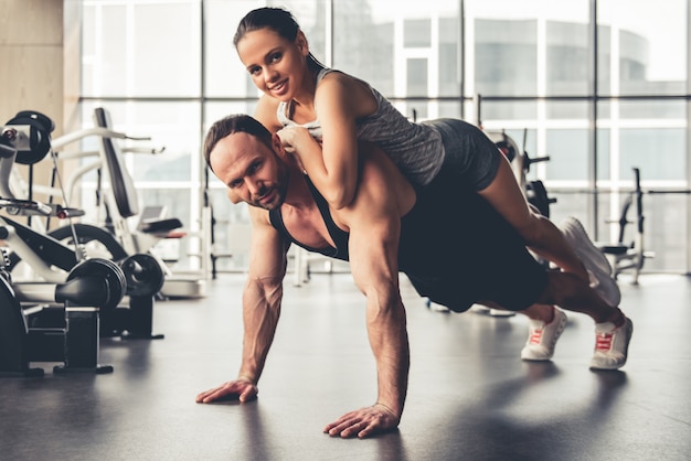 Attractive sports people are working out together in gym.