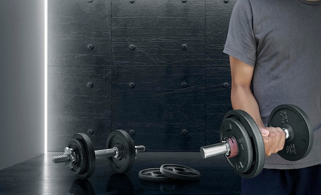 Attractive sports people are working out with dumbbells in the gym The concept of sport and healthy lifestyle