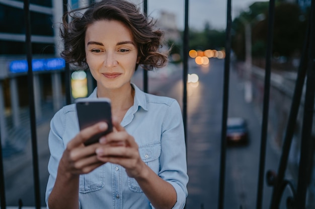 Attractive stylish woman walking in street using smartphone