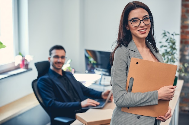 Attractive successful business partner young man and woman posing at the photo front