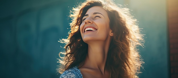 Attractive woman on blue city wall with sunshine in summer Smiling she gazes towards blank space for text