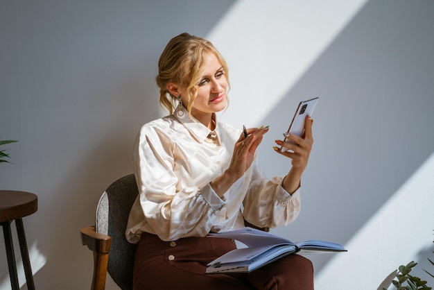 Attractive woman in business clothes with a smartphone in her hands next