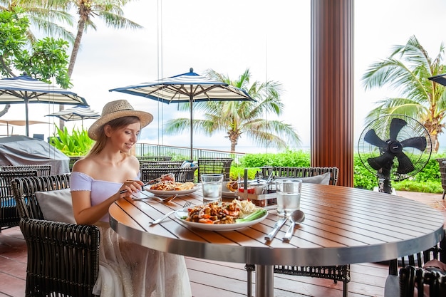 Attractive woman eats italian pasta in outdoor restaurant or cafe prepared food