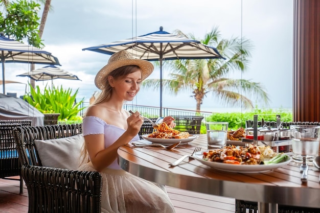 Attractive woman eats italian pasta in outdoor restaurant or cafe prepared food