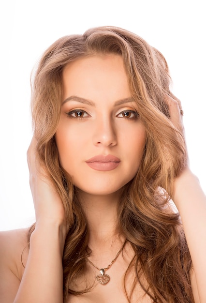 Attractive woman face with nude makeup at studio over a white background