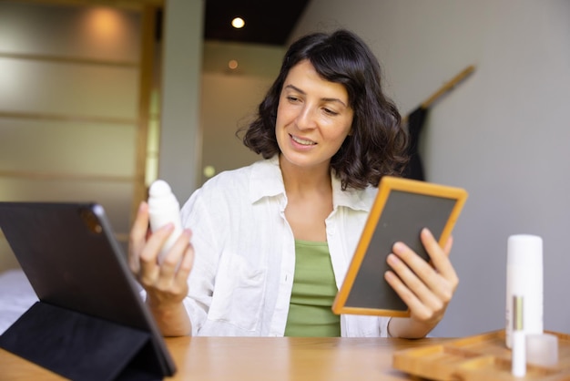 Attractive woman holding bottle and reading