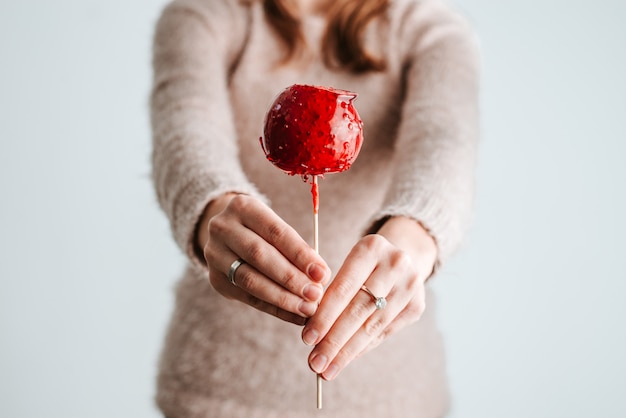 Attractive woman holds holiday sugar candy on stick.