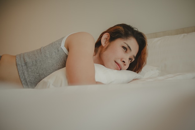 Attractive woman is lying in bed on summer morning