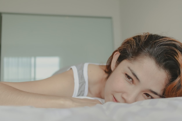 Attractive woman lay on the bed feeling relax and cosy in the morning