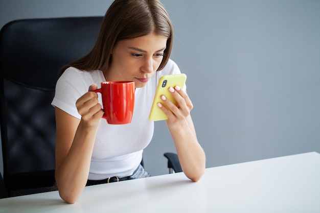 Attractive woman looking at smartphone screen reading media news