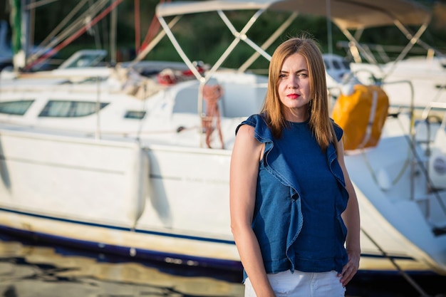 Attractive woman posing on the marina at a sunny summer day at the river