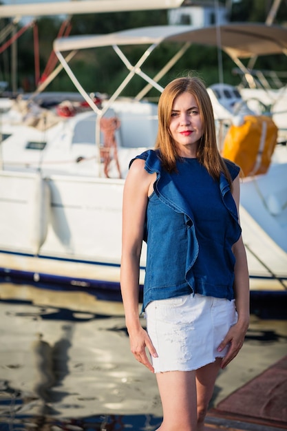 Attractive woman posing on the marina at a sunny summer day at the river