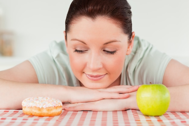 Attractive woman posing with a donut and a green apple