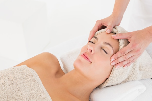 Attractive woman receiving facial massage at spa center