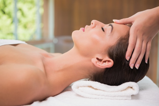 Attractive woman receiving head massage at spa center