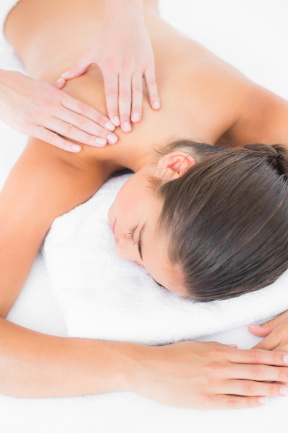 Attractive woman receiving shoulder massage at spa center