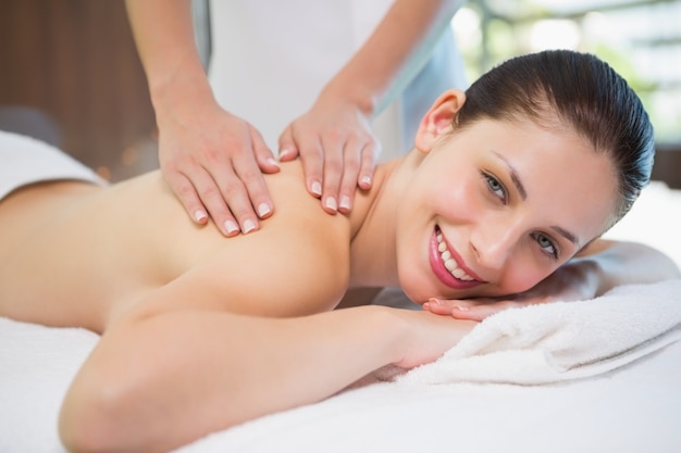 Attractive woman receiving shoulder massage at spa center