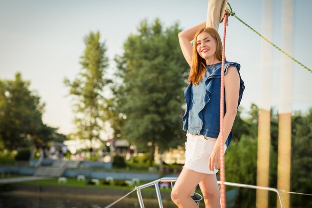 Photo attractive woman relaxing on the nose of the yacht at a sunny summer day at the river