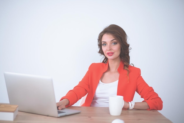 Attractive woman sitting at desk in office working with laptop computer