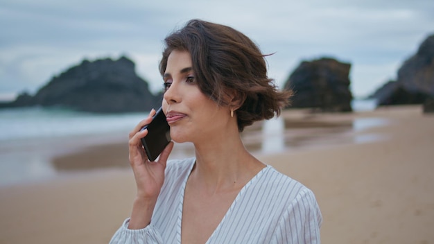 Attractive woman talking mobile phone at shore closeup beach lady making call