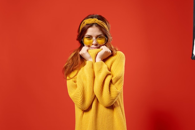 Attractive woman in yellow sweater glasses fashion decoration studio