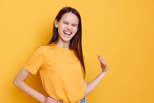 Photo attractive woman in a yellow tshirt emotions summer style isolated background