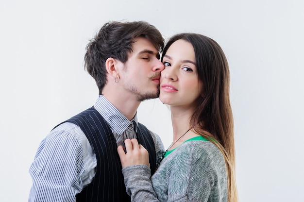 Attractive yang couple stand in a loving embrace looking with expressions.