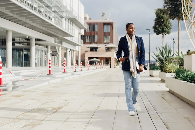 Attractive young african woman walking in the city