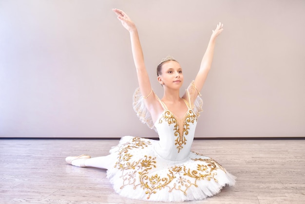 Attractive young ballet dancer acting out beautiful ballerina sitting forward split