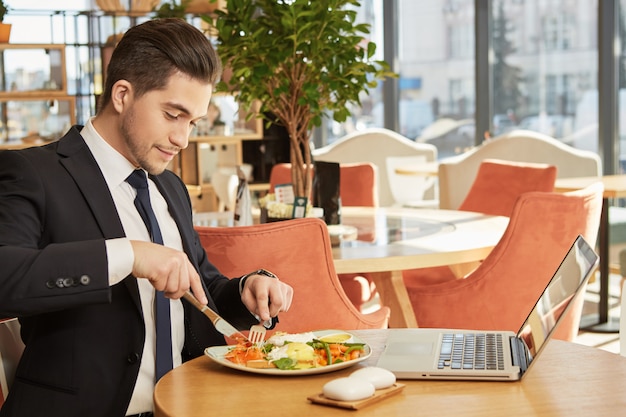 Attractive young business man having breakfast at local cafe