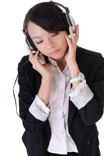 Attractive young business woman enjoying music by Mp3 player and headphone.