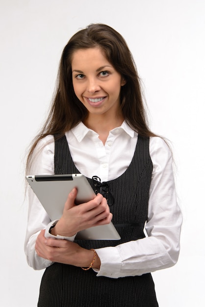 Attractive young business woman holding a digital tablet, on white wall