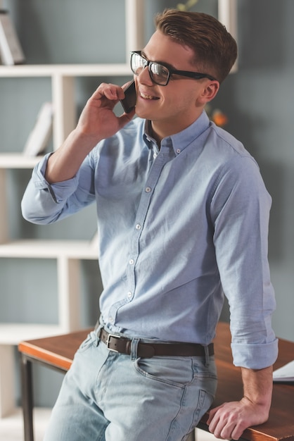 Attractive young businessman in eyeglasses is talking.