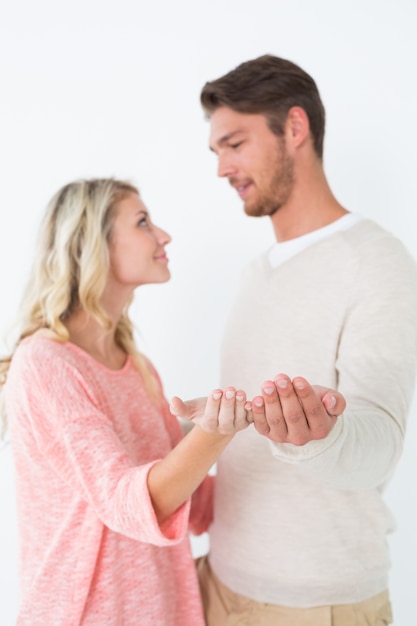 Attractive young couple holding out palms