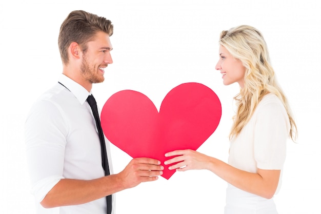 Attractive young couple holding red heart on white background