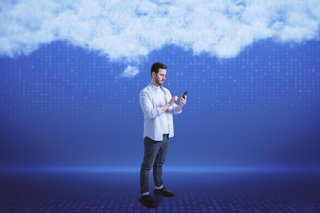 Attractive young european businessman with smartphone on blurry digital blue background with abstract cloud Cloud computing big data and digital transformation concept