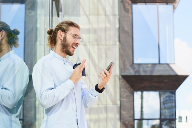 Attractive young man in office clothes speaks facetime