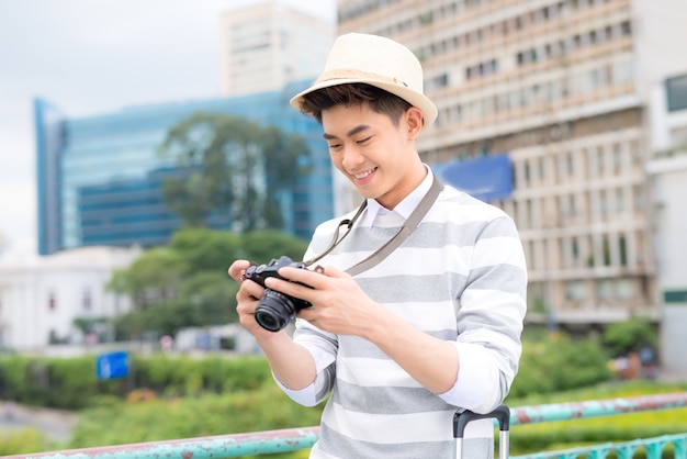 Attractive young man, student or freelance photographer smiles and laughs into camera