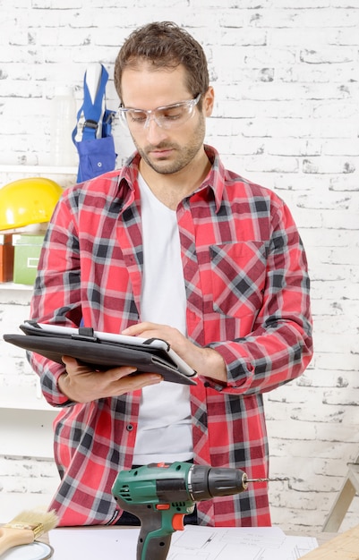 Attractive young man using the tablet for DIY