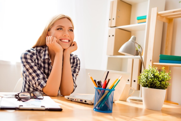 Attractive young smiling woman having break and dreaming