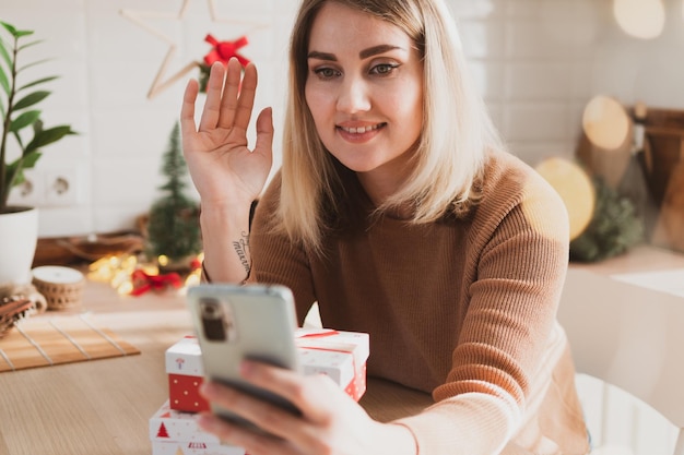 Attractive young woman accepts congratulations for christmas and new year by mobile phone