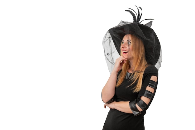 Photo attractive young woman in a black witch hat looks with surprise halloween costume white background space for text